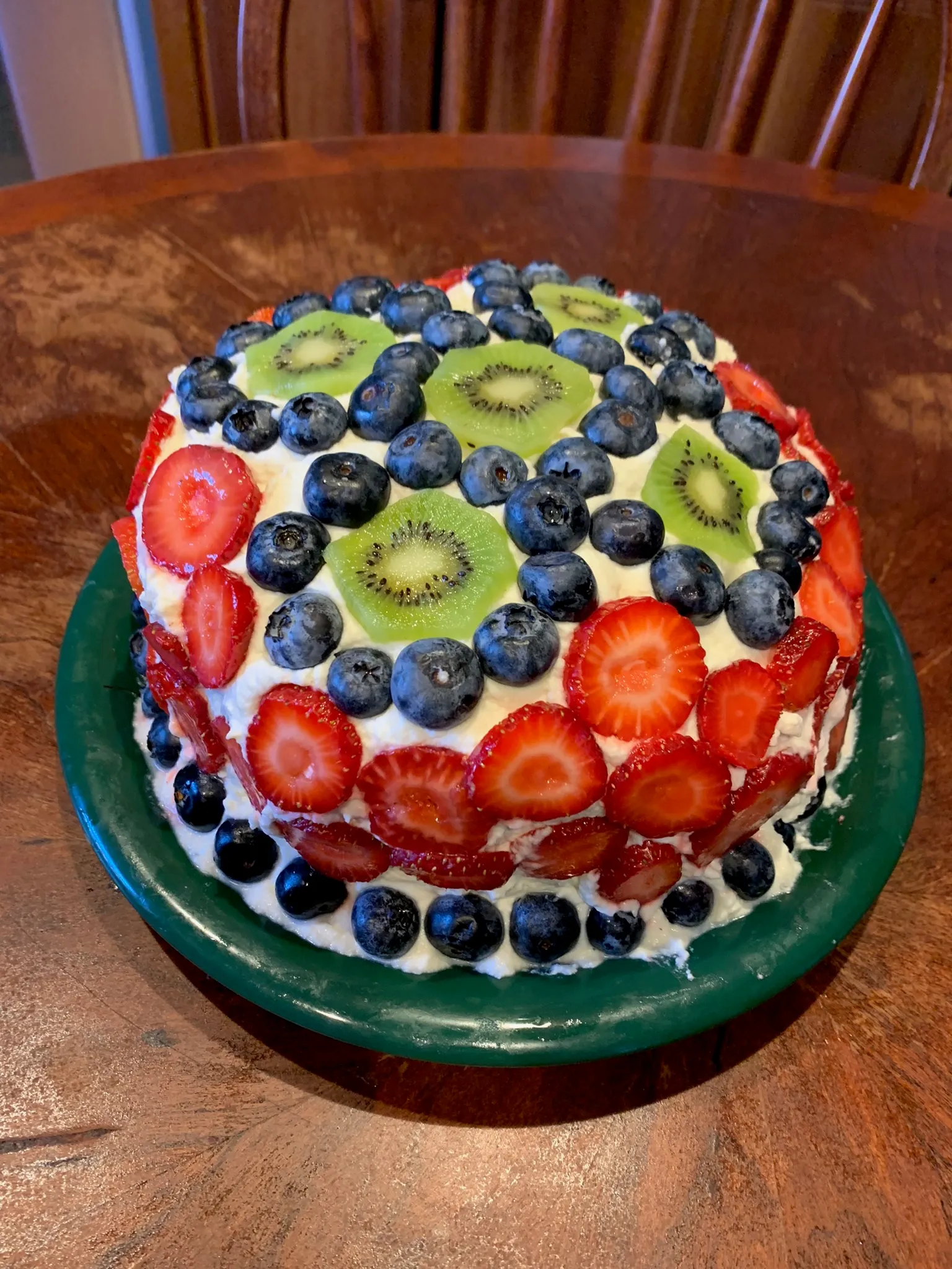 Fresh fruit cream cake with berries and kiwi